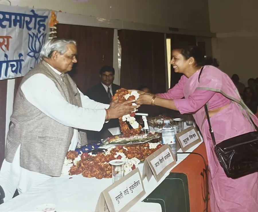 Mira Aggarwal garlanding Shri Atal Bihari Vajpayee at a BJP Mahila Morcha function, with Mridula Sinha and Sumati Tai Suklikar on the dais